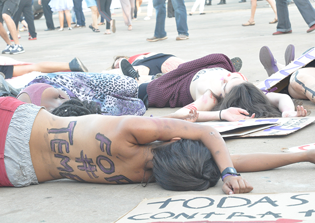 Foto mostra mulheres simulando sua própria morte, representando a violência de gênero