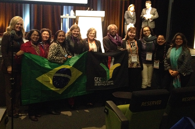 Foto mostra participantes erguendo a bandeira do Brasil na Conferência da Fits