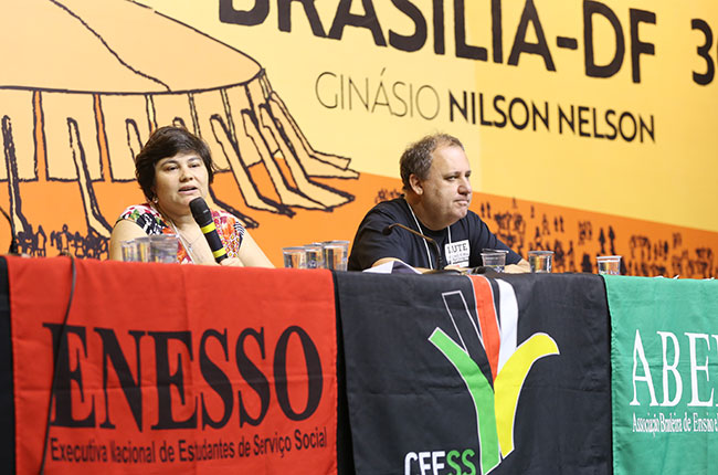 Imagem da mesa que prestou contas do evento, durante a fala da vice-presidente do CFESS, Daniela Neves. 