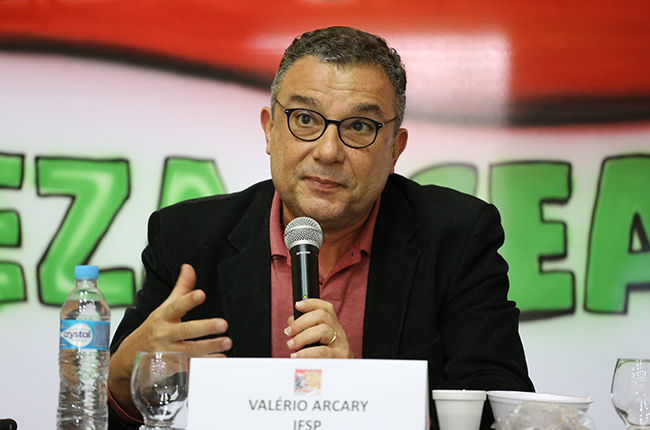 Foto mostra o palestrante Valério Arcary em destaque, palestrando 