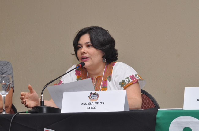 Imagem mostra a conselheira do CFESS, Daniela Neves, durante sua palestra  