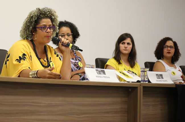 Foto da professora Roseli Rocha falando para o público