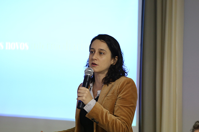 Imagem da jornalista Marina Pita, durante exposição no evento.