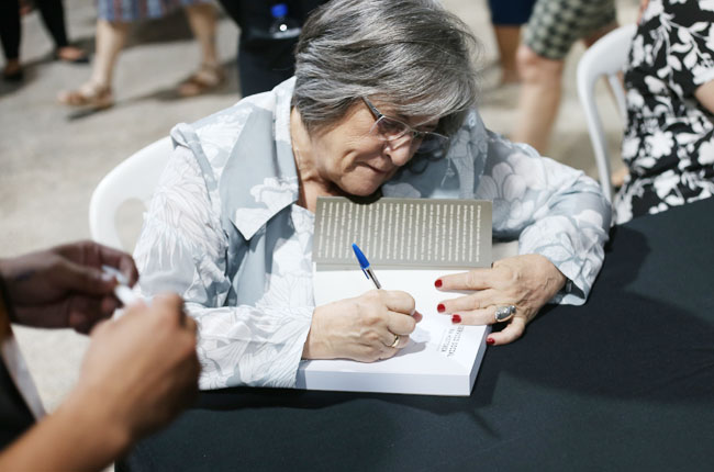 Professora Marilda Iamamoto autografa livro para participantes do evento.