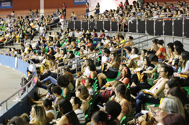 Imagem de participantes que assistiram da arquibancada do ginásio. 