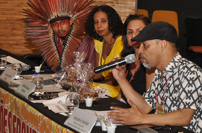 Imagem mostra palestrante Wilson Honório da Silva e outras pessoas na mesa de debates