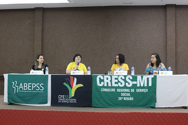 Fotografia enquadra as participantes da mesa de abertura, com Ivna de Oliveira (Abepss), Daniela Neves (CFESS), Andreia Cruz (CRESS-MT) e Fernanda Versiani (Enesso)