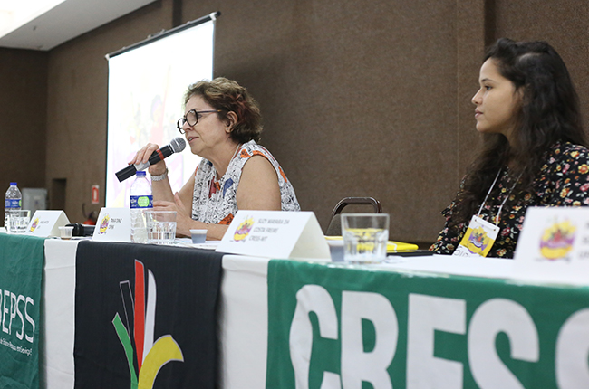 Imagem mostra fotografia da conselheira Tânia Diniz, falando na mesa de encerramento