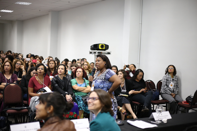 Imagem mostra a conselheira do CFESS Solange Moreira em pé apresentando para o auditório a pesquisa sobre as comunidades terapêuticas