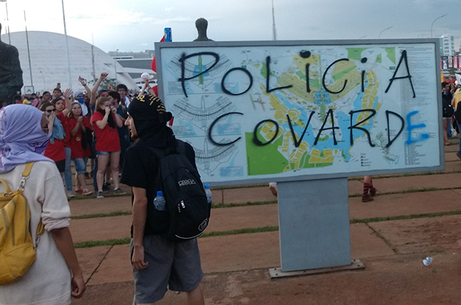 Foto mostra pichação 'Polícia covarde' em placa de Brasília