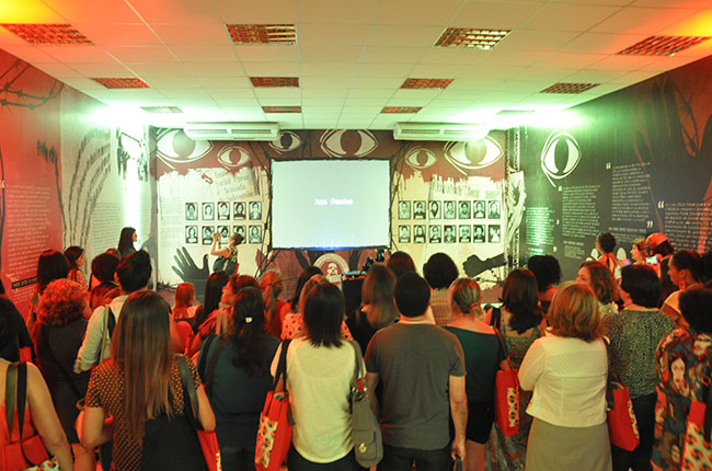 Imagem do público assistindo ao vídeo produzido para a exposição