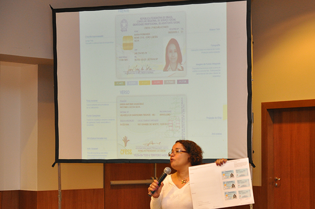 Esther Lemos mostra o novo documento de identidade profissional da categoria, que será lançado em breve (foto: Diogo Adjuto/CFESS)